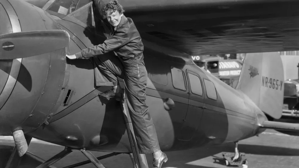 (Original Caption) Amelia Earhart, (1898-1937), first woman to cross the Atlantic Ocean in an airplane. She is shown climbing into the cockpit. Undated photograph.