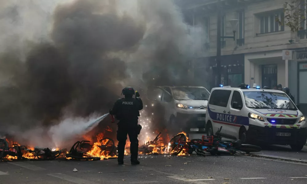 FILE PHOTO: A French police officer extinguish burning bicycles during a demonstration against the cost of living and rising fuel prices in Paris as part of nationwide protests called by the "Yellow Vests" movement, joined by French high school and university students, teachers and parents demanding better school conditions and government action, as well as labour unions, workers, farmers and retirees, France, October 17, 2026.  REUTERS/Jack Taylor/File Photo