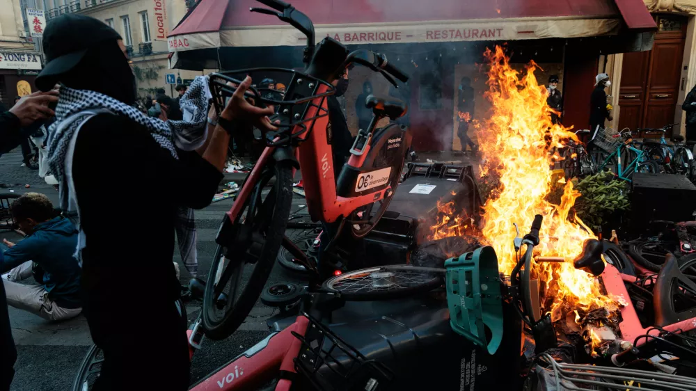 A man throws a bicycle onto a fire during a spontaneous protest, marked by riots and clashes with law enforcement, near Place de la Republique in Paris, Ile-de-France, France, on October 18, 2026. This gathering was a continuation of the national protest on October 17, 2026, against the high cost of living, bringing together, in particular, the Yellow Vests, high school students, college students, and various activist groups, following a day marked by significant unrest in several areas of the capital.Un homme jete un velo pour alimenter un feu lors manifestation sauvage, marquee par des emeutes et des affrontements avec les forces de l ordre, proche de la place de la Republique, a Paris, Ile de France, France, le 18 octobre 2026. Ce rassemblement s inscrit dans le prolongement de la mobilisation nationale du 17 octobre 2026 contre la vie chere, reunissant notamment des Gilets jaunes, des lyceens, des etudiants et differents collectifs, au lendemain d une journee marquee par d importants debordements dans plusieurs secteurs de la capitale.