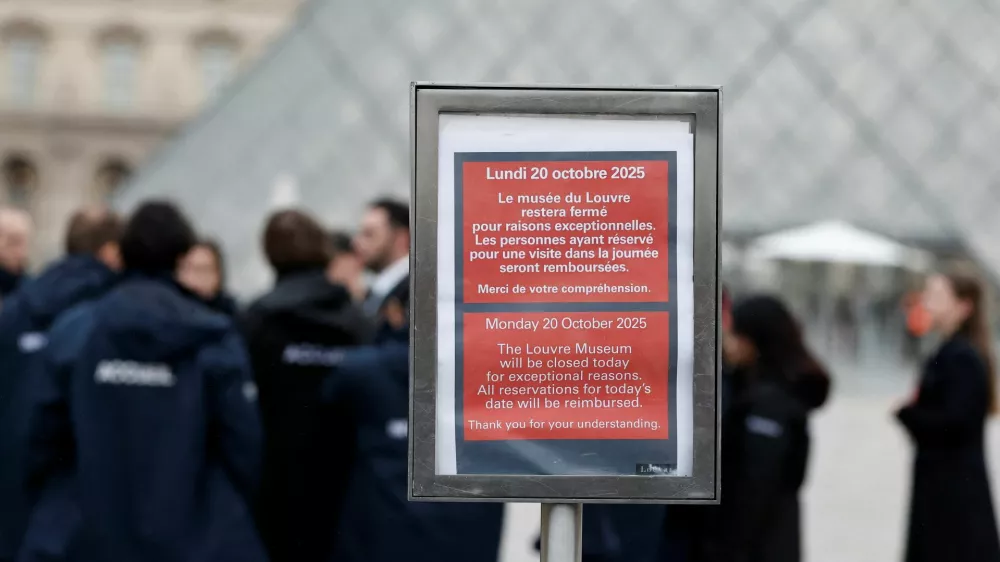A placard which reads "The Louvre Museum will be closed today for exceptional reasons" is seen near the glass Pyramid of the Louvre Museum as the museum remains closed the day after a spectacular jewel heist by thieves who broke into the landmark by using a crane and smashing an upstairs window, stealing priceless jewelry from an area that houses the French crown jewels before escaping on motorbikes, in Paris, France, October 20, 2025. REUTERS/Benoit Tessier