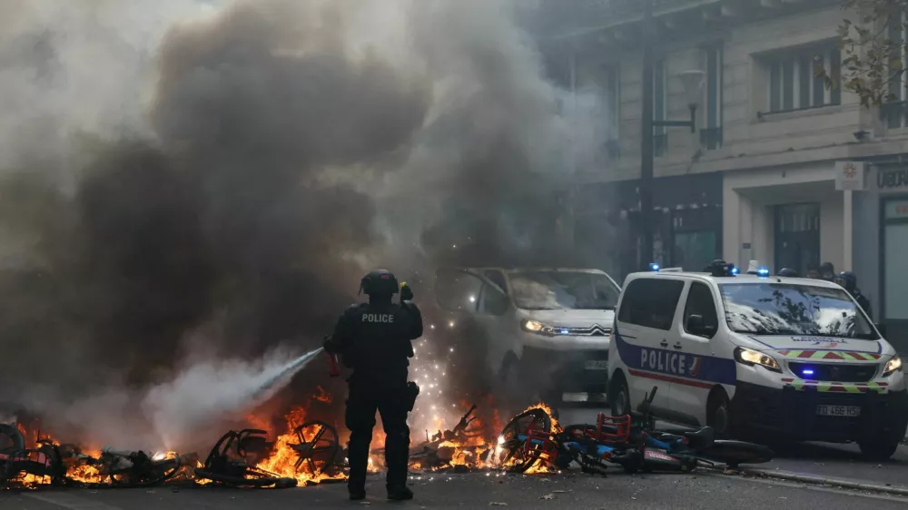 FILE PHOTO: A French police officer extinguish burning bicycles during a demonstration against the cost of living and rising fuel prices in Paris as part of nationwide protests called by the "Yellow Vests" movement, joined by French high school and university students, teachers and parents demanding better school conditions and government action, as well as labour unions, workers, farmers and retirees, France, October 17, 2026.  REUTERS/Jack Taylor/File Photo