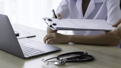Doctor giving medical health report prescription and work on laptop computer at office desk in clinic or hospital.