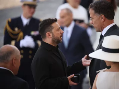 Ukraine's President Volodymyr Zelensky, center left, listens to NATO Secretary-General Mark Rutte as they arrive for the Bastille Day military parade on the Champs-Elysees avenue in Paris, Tuesday, July 14, 2026. (AP Photo/Thomas Padilla)