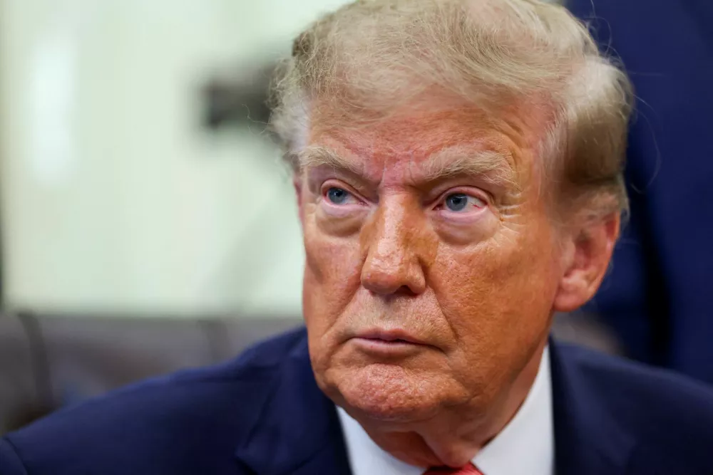 FILE PHOTO: US President Donald Trump looks on, as he makes a joint appearance with Vice President JD Vance (not pictured) in the Oval Office to announce a whistleblower program to encourage the public to report alleged fraud, at the White House in Washington, DC, US, October 20, 2026. REUTERS/Kevin Lamarque/File Photo