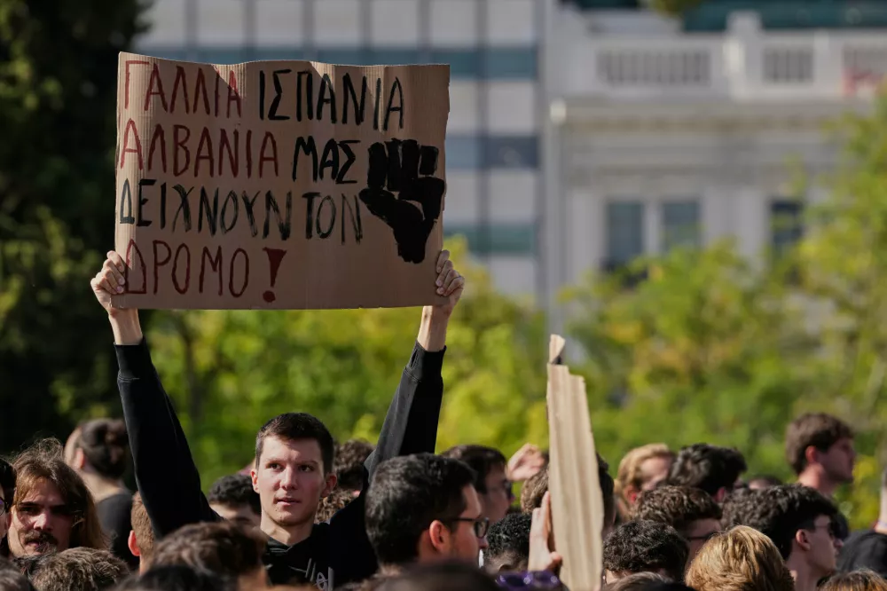 Protesters take part in a rally organized by teachers and students demanding improvements to education and measures to address the rising cost of living in Athens, Greece, Wednesday, Oct. 21, 2026. Banner reads in Greek: " "France, Spain and Albania are showing us the way." (AP Photo/Thanassis Stavrakis)