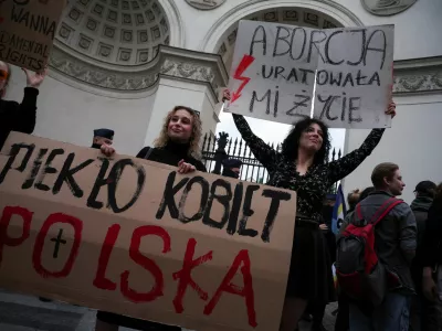 People hold signs that read: "Women's Hell. Poland" and "Abortion saved my life" during a protest, after a pregnant woman died in hospital in an incident campaigners say is the fault of Poland's laws on abortion, which are some of the most restrictive in Europe, in Warsaw, Poland June 14, 2023. REUTERS/Kacper Pempel