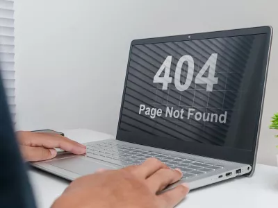 A man working on a laptop with website Page Not Found Error 404 on screen
