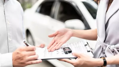 Automotive business, car sale or rental concept: Happy customer with car dealer agent making deal and signing on agreement document contract in auto showroom or car dealer office.