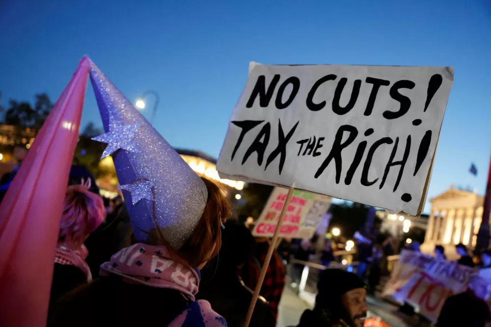 A student holds a placard during a protest against the government's cost-cutting for universities, in front of the Austrian parliament in Vienna, Austria, October 22, 2026. REUTERS/Lisa Leutner