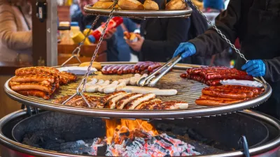 Grilling sausages on barbecue grill at a food stall of Christmas market winter wonderland in London