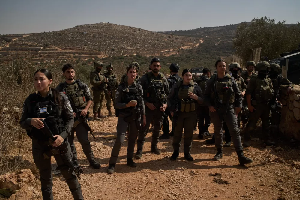 Members of Israeli forces block a road preventing Palestinians from reaching groves to harvest olives in the West Bank town of Turmus Ayya, Wednesday, Oct. 21, 2026. (AP Photo/Leo Correa)