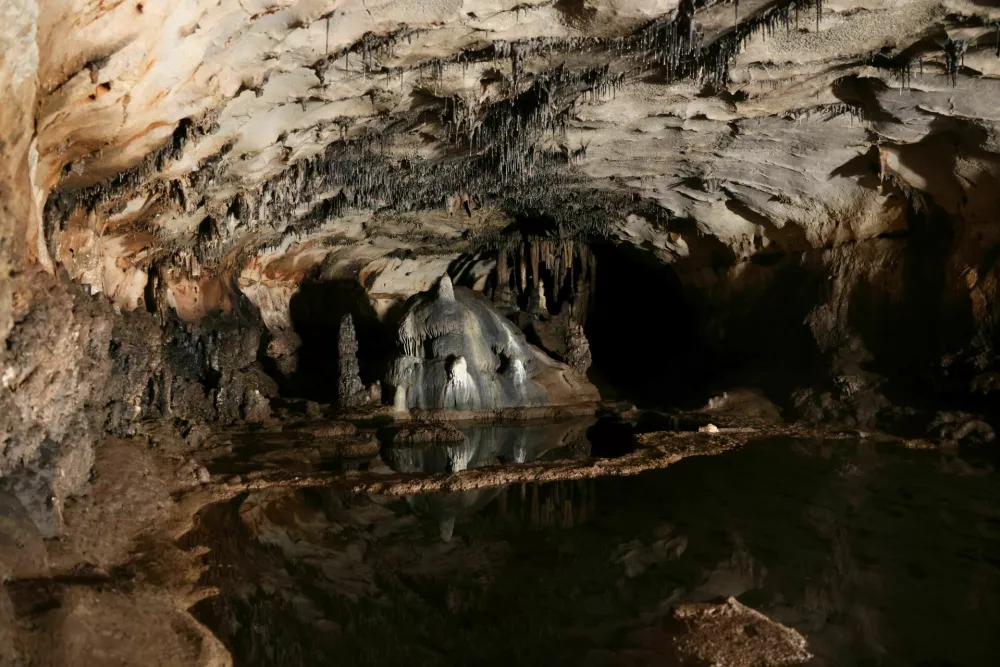 Delno poplavljena dvorana jame Cova Dones, v kateri so raziskovalci odkrili večino prazgodovinskih jamskih upodobitev. Jama je bila v različnih obdobjih kraj človekovega ustvarjanja in verjetno tudi obrednih dejavnosti. / Foto: &copy; Archaeosymbol Research Team