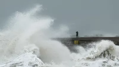 A person watches from the beach as waves crash onto Newhaven Harbour during Storm Austen in Newhaven, Britain, October 23, 2026. REUTERS/Toby Melville
