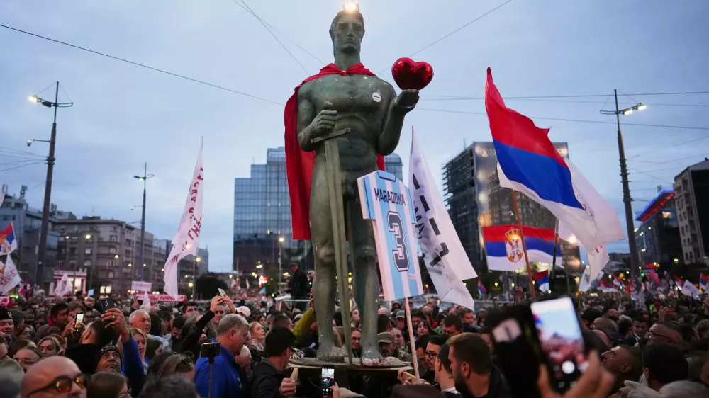People hold a replica of the Serbian capital landmark The Victor or Pobednik statue during the final "Student List &ndash; Students Win" rally ahead of a parliamentary election in Belgrade, Serbia, Thursday, Oct. 22, 2026. (AP Photo/Petr David Josek)