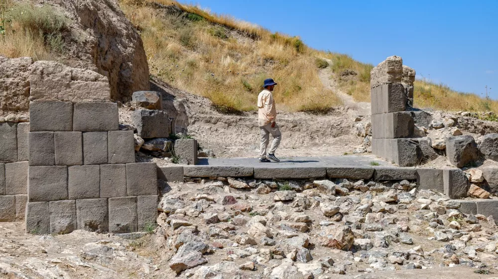 An archaeologist walk walks through the ruins of the fortress of Ayanis near Van, in eastern Turkey, on August 4, 2026. Although it emerged later than the great Mesopotamian kingdoms of Assyria, Sumer, and Babylon, Urartu succeeded in uniting the tribal communities of the Autoru Mountains into a centralized state, building fortresses, provincial capitals, irrigation networks, and vast storage facilities to support an agricultural economy.,Image: 1121981093, License: Rights-managed, Restrictions: Graphic ContentTO GO WITH AFP STORY BY ANNE CHAON, Model Release: no 