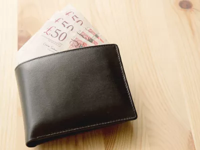 High Angle View Of Modern Black leather Men's Wallet With Pound Cash On The Old Rough Wood Textured Background With Copy Space / Foto: Photobuay