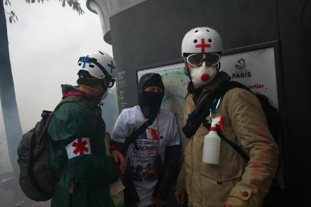 Street medics check a person amid clashes and tear gas during a demonstration organised by labour unions in Paris as part of nationwide protests called by the "Yellow Vests" movement joined by French high school and university students against the cost of living and rising fuel prices, in France, October 24, 2026. REUTERS/Pedro Nunes