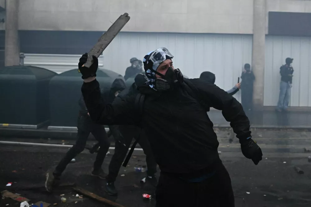 A masked protester throws an object amid clashes and tear gas during an authorised demonstration organised by labour unions in Paris as part of nationwide protests called by the "Yellow Vests" movement joined by French high school and university students against the cost of living and rising fuel prices, in France, October 24, 2026. REUTERS/Dylan Martinez