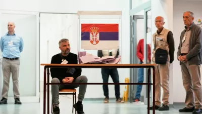 Election officials stand around a ballot box during a parliamentary election in Belgrade, Serbia, Sunday, Oct. 25, 2026. (AP Photo/Darko Vojinovic)