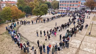 People wait in lines outside a polling station to cast their votes during a parliamentary election in Belgrade, Serbia, Sunday, Oct. 25, 2026. (AP Photo/Armin Durgut)