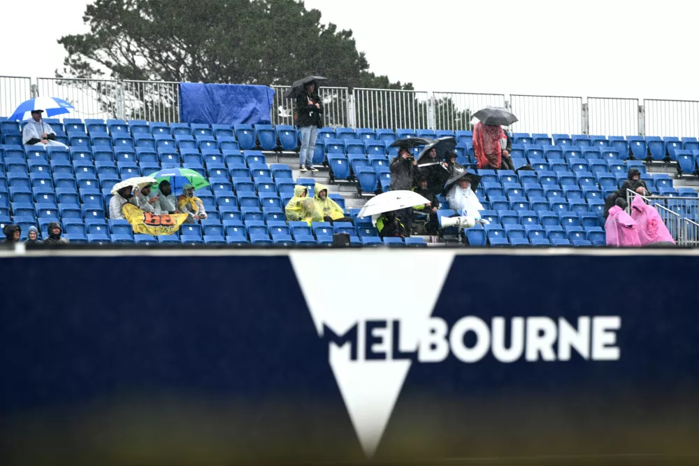 Spectators sit in the rain prior to the MotoGP race being called off due to bad weather for the Australian Motorcycle Grand Prix at the Phillip Island near Melbourne, Australia, Sunday, Oct. 25, 2026. (Joel Carrett/AAP Image via AP)