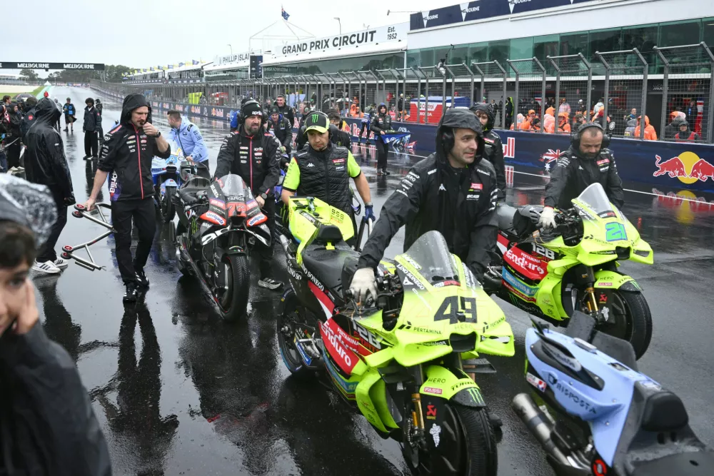 Pit crew members clear bikes from the straight after the MotoGP race was called off due to bad weather for the Australian Motorcycle Grand Prix at the Phillip Island near Melbourne, Australia, Sunday, Oct. 25, 2026. (Joel Carrett/AAP Image via AP)
