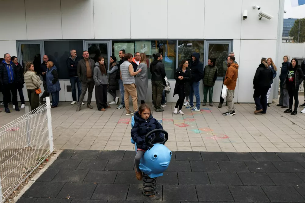 A girl plays outside a polling station as people queue to cast their votes during the parliamentary election in Belgrade, Serbia, October 25, 2026. REUTERS/Marko Djurica
