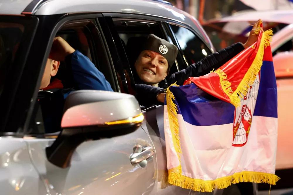 A person holds a Serbian flag as supporters of the electoral list "Student List - Students Win" celebrate following the first results of the parliamentary election in Belgrade, Serbia, October 25, 2026. REUTERS/Zorana Jevtic