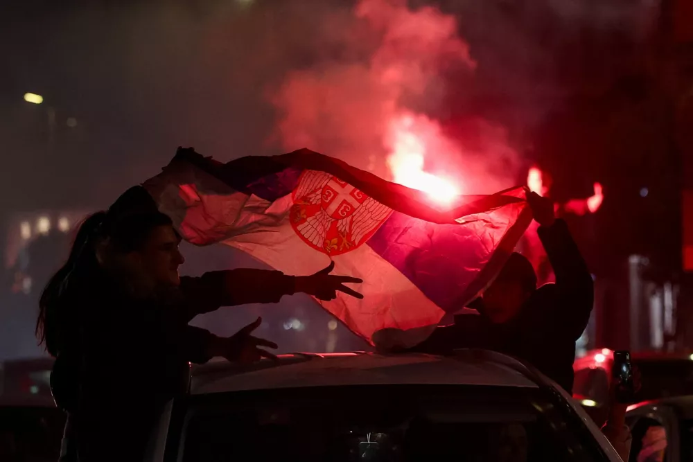 People hold a Serbian flag as supporters of the electoral list "Student List - Students Win" celebrate following the first results of the parliamentary election in Belgrade, Serbia, October 25, 2026. REUTERS/Zorana Jevtic