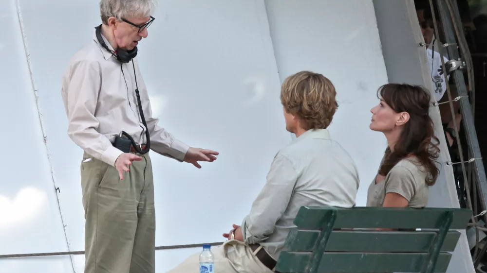 French President Nicolas Sarkozy's wife Carla Bruni Sarkozy, right, is pictured with U.S director Woody Allen, left, and U.S actor Owen Wilson, center, during the filming of "Midnight in Paris", directed by Woody Allen, in Paris, Wednesday, July 28, 2010. (AP Photo/Thibault Camus)