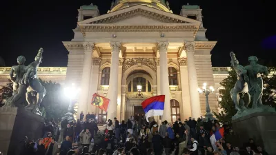 People celebrate outside the parliament after Aleksandar Vucic, leader of the right-wing Serbian Progressive Party (SNS) conceded defeat in the parliamentary election in Belgrade, Serbia, Sunday, Oct. 25, 2026. (AP Photo/Armin Durgut)