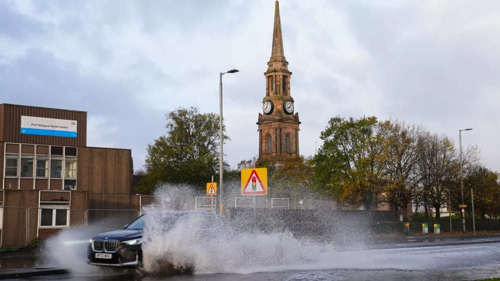 A car drives on the flooded A8 in Port Glasgow, Scotland, Sunday, Oct. 25, 2026, after Storm Boelo passed through the area. (Jane Barlow/PA via AP)