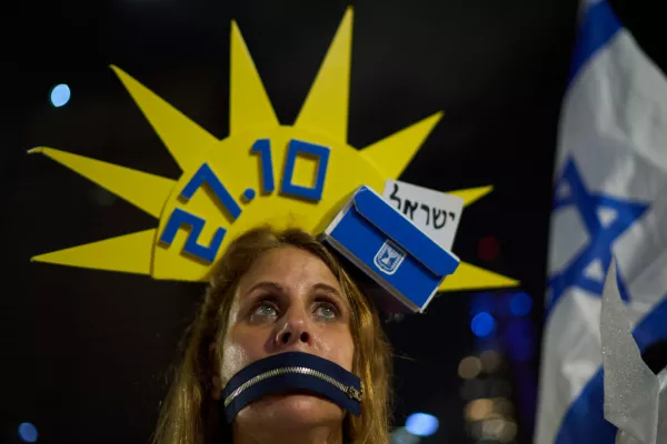 Hila Galili wears a headdress decorated with a ballot box during an anti-government rally ahead of the country's general election, Saturday, Oct. 24, 2026, in Tel Aviv, Israel. (AP Photo/David Goldman)