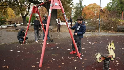 Youngsters clean pro-ruling party stickers in a park used as a camp by supporters of the right-wing Serbian Progressive Party (SNS) where tents and vehicles were set on fire by celebrating crowds after Aleksandar Vucic, the party leader conceded defeat in the parliamentary election, held on Sunday, in Belgrade, Serbia, Monday, Oct. 26, 2026. (AP Photo/Armin Durgut)