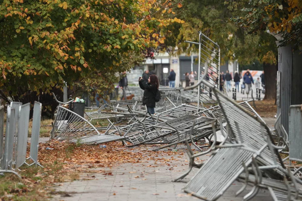 A woman takes pictures in a park used as a camp by supporters of the right-wing Serbian Progressive Party (SNS) where tents and vehicles were set on fire by celebrating crowds after Aleksandar Vucic, the party leader conceded defeat in the parliamentary election, held on Sunday, in Belgrade, Serbia, Monday, Oct. 26, 2026. (AP Photo/Armin Durgut)