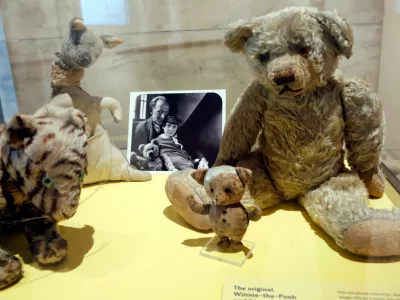FILE - A photograph of author A. A. Milne with his son Christopher Robin is displayed beside Milne's son Christopher Robin's beloved teddy bear, the inspiration for "Winne-the-Pooh," at the New York Public Library, Monday, Sept. 30, 2013, in New York. (AP Photo/Kathy Willens,File)