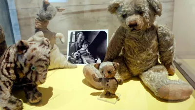 FILE - A photograph of author A. A. Milne with his son Christopher Robin is displayed beside Milne's son Christopher Robin's beloved teddy bear, the inspiration for "Winne-the-Pooh," at the New York Public Library, Monday, Sept. 30, 2013, in New York. (AP Photo/Kathy Willens,File)