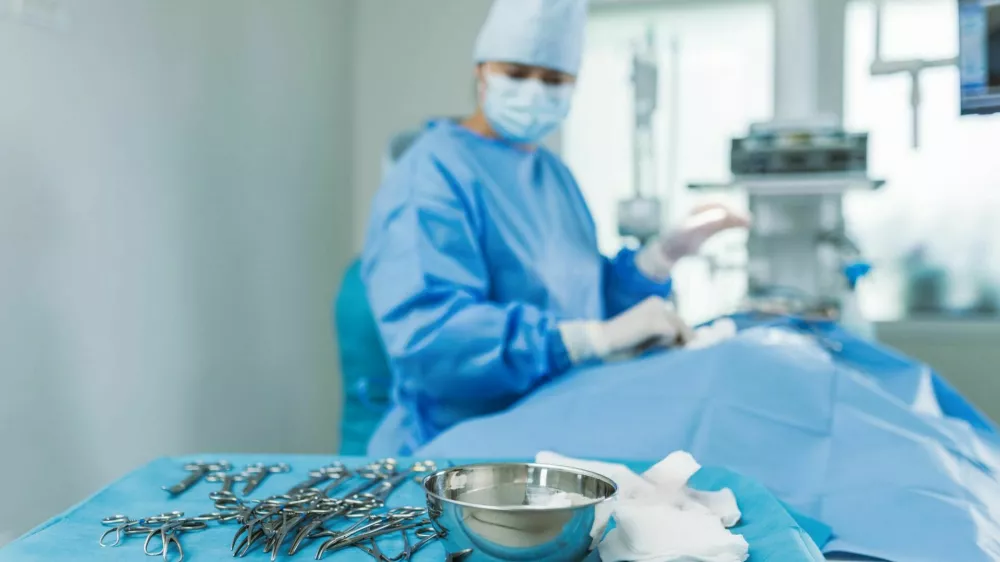 A surgical team collaborates in a hospital OR, using professional equipment and sterile techniques for a procedure.