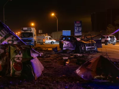 Emergency workers clear debris and damaged road infrastructure near a destroyed car following a Russian overnight strike in Kyiv, Ukraine, Tuesday, Oct. 27, 2026. (AP Photo/Dan Bashakov)
