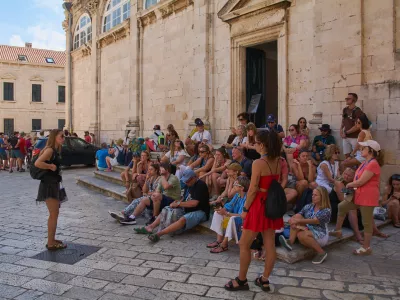 Dubrovnik. Croatia - November 01, 2025: Visitors gather on the stone steps of the famous baroque stairway in Stari Grad on a sunny day.