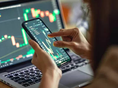 Closeup - Woman is checking Bitcoin price chart on digital exchange on smartphone, cryptocurrency future price action prediction.