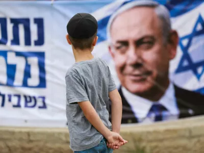 A child looks at a banner depicting Israeli Prime Minister and Likud party leader Benjamin Netanyahu, during the country's national elections in Jerusalem, October 27, 2026. REUTERS/Ronen Zvulun