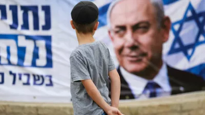 A child looks at a banner depicting Israeli Prime Minister and Likud party leader Benjamin Netanyahu, during the country's national elections in Jerusalem, October 27, 2026. REUTERS/Ronen Zvulun