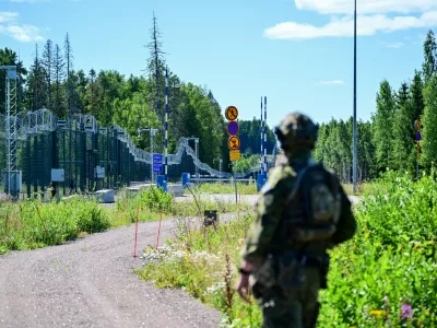 An officer from a special unit of the Finnish Border Guard stands in front of the border fence at a closed border crossing on the Finnish-Russian border. / Foto: Sebastian Christoph Gollnow
