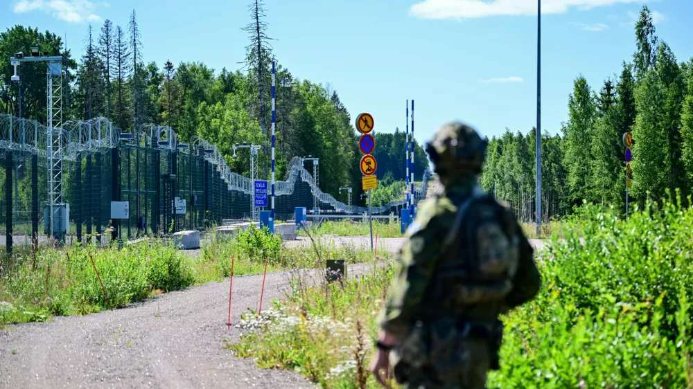 An officer from a special unit of the Finnish Border Guard stands in front of the border fence at a closed border crossing on the Finnish-Russian border. / Foto: Sebastian Christoph Gollnow