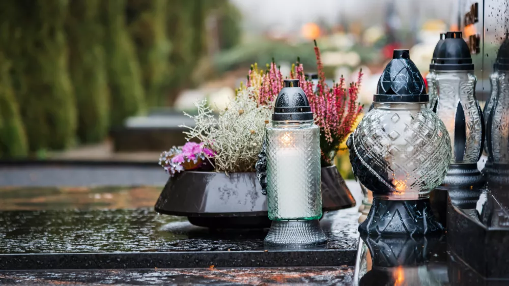 All Saints' Day and burning candles and flowers on the graves.Candles on graves symbolize the memory of the dead on November 1.Catholic cemetery during All Saints' Day.Selective focus.