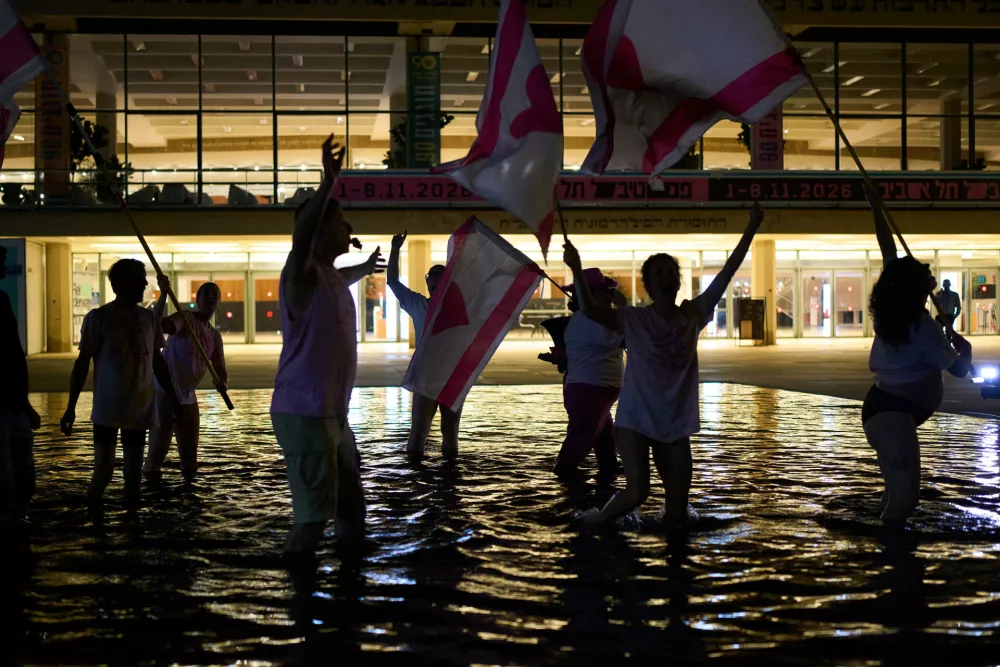 People wave flags as they wade in a reflecting pool to celebrate early exit poll results for Israel's general election in Tel Aviv, Israel, Tuesday, Oct. 27, 2026. (AP Photo/Oded Balilty)