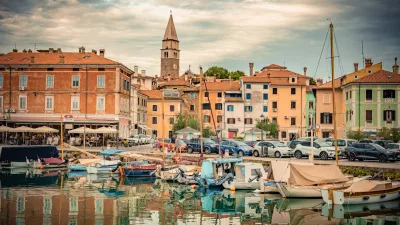 St. Maurus's Parish Church and Bell Tower Reflected in the Calm Waters of Izola Harbor, Slovenia