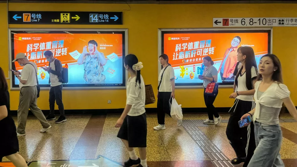 FILE PHOTO: People walk past a Meituan billboard displayed on a wall in a metro station in Shanghai, China, on July 6, 2026. REUTERS/Andrew Silver/File Photo