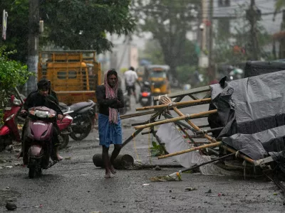 A man walks past the destruction caused at Kakinada, India, after Cyclone Arnab crossed the Andhra Pradesh coast in the early hours of Wednesday, Oct. 28, 2026. (AP Photo/Mahesh Kumar A.)
